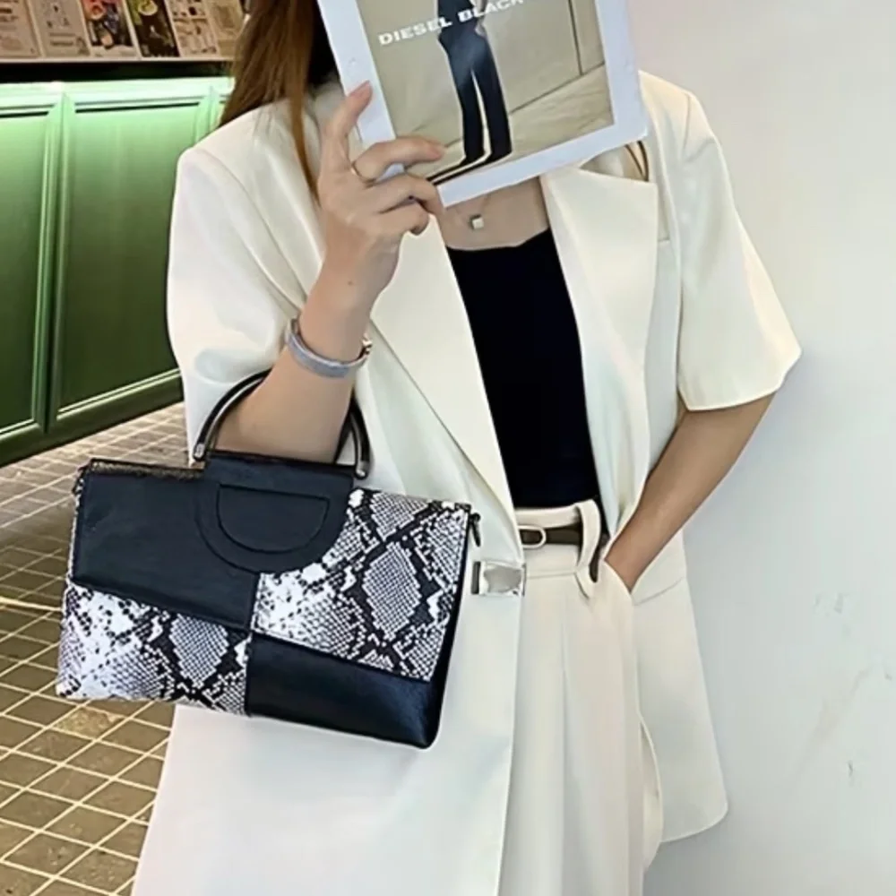 Luce black and white snakeskin clutch bag